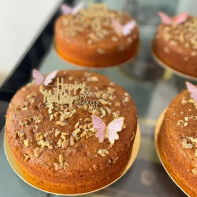 A set of lovely walnut cakes prepared for Mother's Day. Topped with chopped walnuts and delicate butterfly decorations, these cakes are a simple and heartfelt way to celebrate personal occasions.