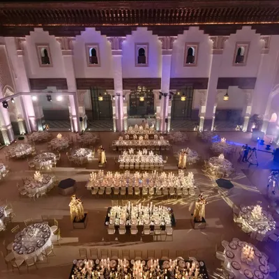 A palatial ivory-and-gold sit-down dinner in a grand courtyard in Marrakech. The layout with long and round tables created a formal yet social atmosphere to toast the newlyweds.