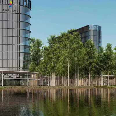 A view of a modern tech campus where glass towers rise from a forest-inspired landscape. The large water feature in the foreground not only adds serenity but also creates a natural boundary between the public and private zones of this mixed-use development.