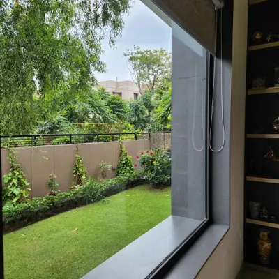 A large window in one of our residential projects perfectly frames the lush green garden outside, bringing the peace of nature indoors. We prioritize creating such connections to achieve a resort-like living experience in the city.