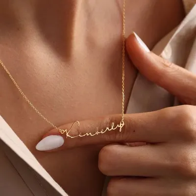 A close-up view of the 'Kimberly' script necklace, showcasing the delicate yet durable chain and the precision of the lettering. This is a timeless piece that rests beautifully on the collarbone.