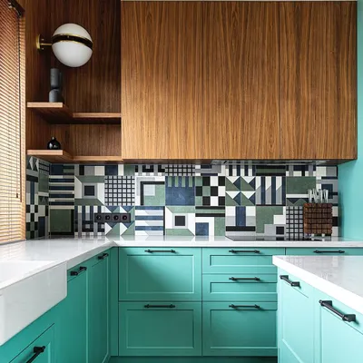 Luxury redefined. This kitchen design showcases a bold use of color and pattern, with teal cabinets, a striking geometric tile backsplash, and rich wood accents. It's a perfect example of a kitchen that reflects personality.
