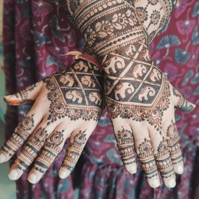 A beautiful design featuring a grid of baby elephants on the back of the hand. It's a traditional pattern with a cute and modern twist.