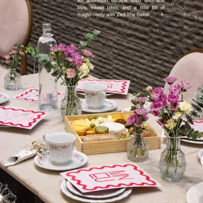 An afternoon escape is complete with a beautifully set table. For this high tea, I arranged a spread featuring a wooden cheese and fruit platter, fine china, and fresh floral bouquets to create a warm and inviting atmosphere for a private gathering.