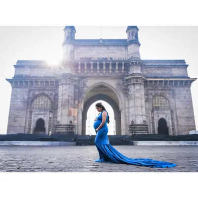 A truly iconic maternity shot at the Gateway of India. My royal blue fitted gown with its long, flowing train creates a stunning silhouette against the historic landmark, making for a powerful and memorable photo.