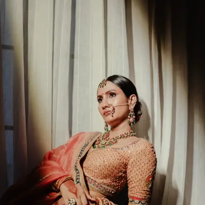 A moment of quiet reflection. We captured Shristi in the soft window light, creating a portrait that is both serene and powerful. The lighting highlights the delicate details of her attire and her calm, confident expression.
