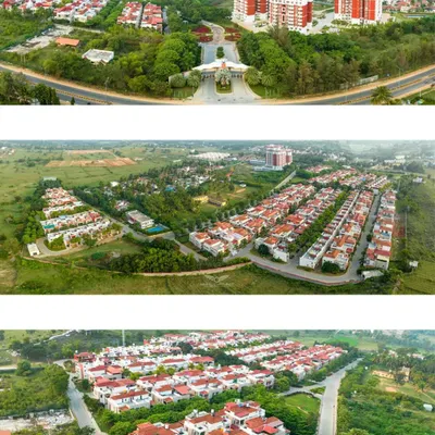 A wide aerial shot of the entrance to Zuari Garden City, showing the relationship between the apartment towers, villa community, and surrounding green landscape.