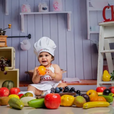 Meet the tiniest chef in town, serving cuteness with a sprinkle of giggles and a side of fruits.