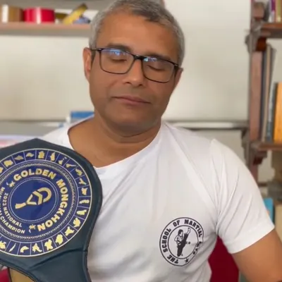 Our founder and chief instructor, Ashwin Naidu, holding a national championship belt from the Golden Mongkhon series. Our leadership's success in the ring is the bedrock of our training credibility.