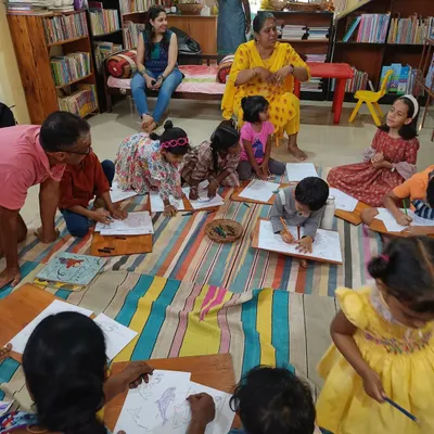 Children are deeply engaged in a coloring activity related to our story about sea animals. Using lapboards on the floor creates a relaxed and comfortable crafting environment.