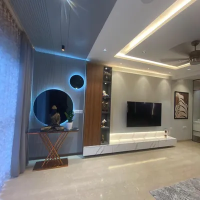 This living room combines modern design with a touch of tranquility, featuring a Buddha statue, circular wall mirrors, and integrated blue backlighting for a calming ambiance.
