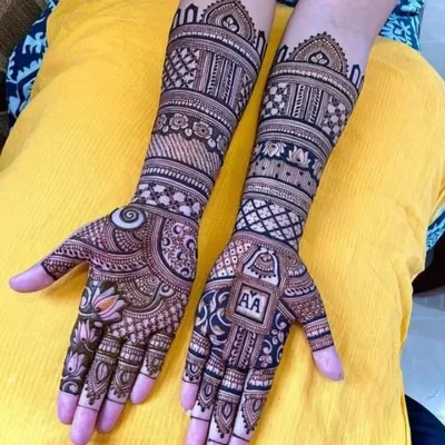 A perfect example of a personalized engagement mehandi. This design features the couple's initials "AA" in a neat block on one hand, balanced with a lotus motif on the other.