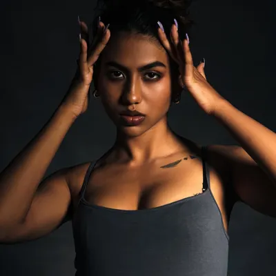 A powerful close-up portrait using dramatic lighting to sculpt the model's features. The intensity in her eyes is the focal point of this shot.
