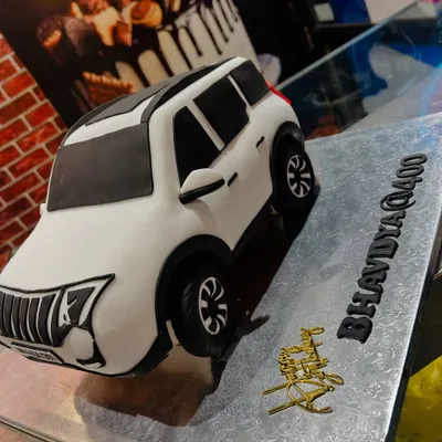 A fully edible, hand-sculpted 3D cake of a white Mahindra XUV400. I recreated every detail, from the grille to the license plate, for a true car lover.