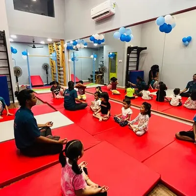 A quiet moment during class where students sit together on the mats with their instructors. This shows how we structure our sessions to include both high-energy activities and focused, calm periods for instruction and rest.