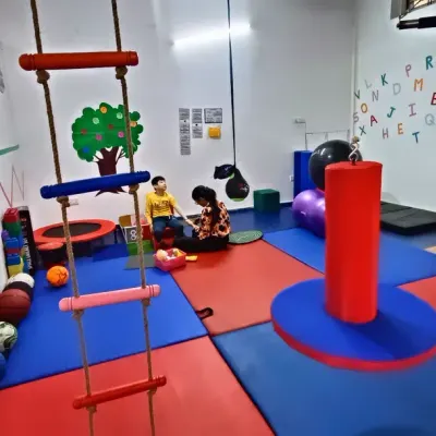 A wide view of our well-equipped Occupational Therapy Unit in Gurgaon. The space includes a climbing ladder, trampoline, therapy balls, and padded floors for safe exploration.
