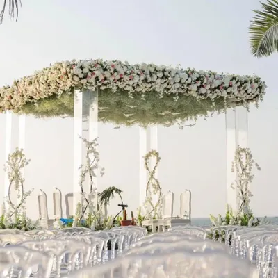 This all-white floral mandap set against the open sea is the definition of a dream wedding. I designed this to feel both grand and intimate, using transparent acrylic pillars so the structure wouldn't obstruct the beautiful ocean view, creating a serene and modern ceremony space.