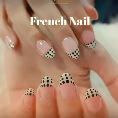A playful and chic twist on a classic. These almond-shaped nails feature a modern French manicure with a fun black polka dot pattern on the tips for a unique style statement.