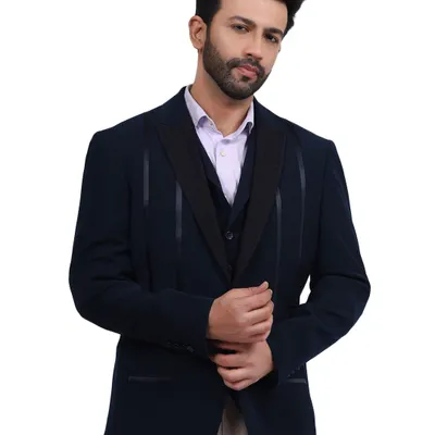 A male model looking sharp in a navy blue three-piece suit. The clean white background and professional lighting make this a perfect shot for a formal wear catalogue or e-commerce store.