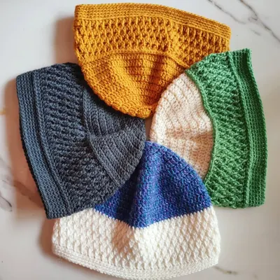 This is a collection of unisex beanies I made, each featuring a textured Alpine stitch panel. It's a versatile pattern that looks great in any color, from mustard yellow to classic grey.