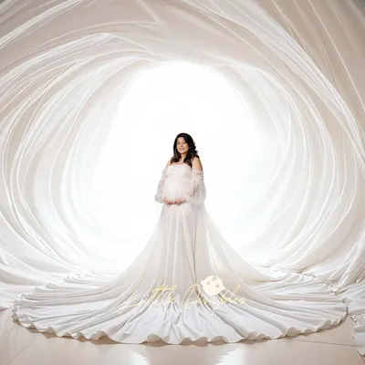 An all-white studio session creates such a heavenly and pure look. Here, we used layers of flowing white fabric to create a stunning cocoon effect for this diva mom-to-be.