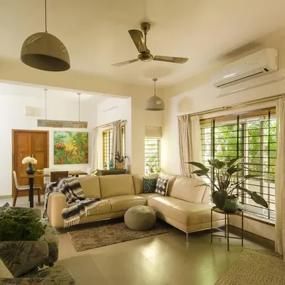 The renovated living room, where we replaced small, dark windows with large sliding ones to flood the space with natural light. The open layout now connects the living and dining areas, creating a more fluid and sociable environment.