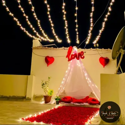 I transformed this terrace into a romantic haven with a canopy tent, a "Love" balloon, and a pathway of red rose petals. The overhead strings of fairy lights create a magical, star-lit ambiance for a perfect date night.