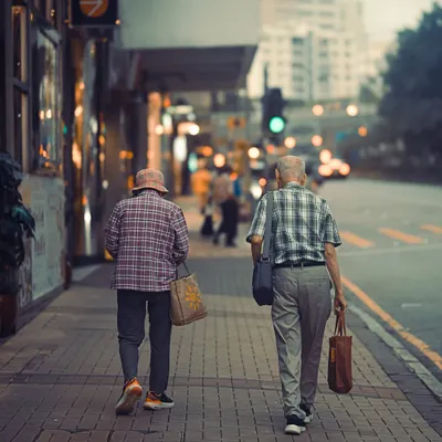 An elderly couple walking together on a sidewalk in Kowloon, Hong Kong. This is the heart of street photography for me, capturing universal stories of love and companionship in the middle of a bustling city.