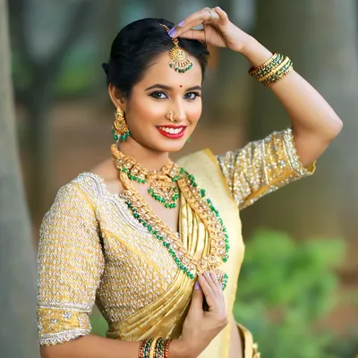 Feel like royalty in this classic golden Kanchi tissue saree. Paired with a heavily hand-embroidered blouse, this ensemble is a timeless choice for a South Indian wedding muhurtham.