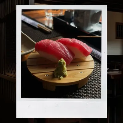 The quality of our ingredients is paramount. This simple, elegant presentation of Tuna Nigiri showcases the freshness of the fish, served on a bed of perfectly seasoned rice. It's a small bite that speaks volumes about our dedication to authentic flavor.