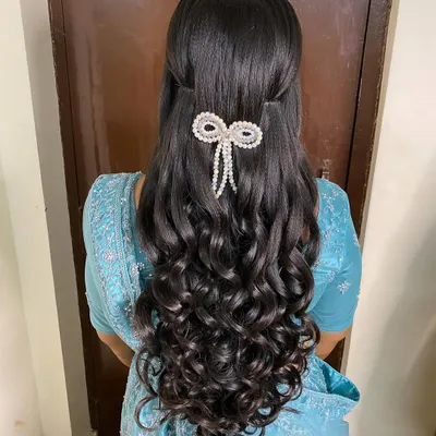A stunning half-updo for a reception, featuring voluminous, perfectly defined curls. I added a beautiful pearl bow accessory to create a look that is both elegant and modern.