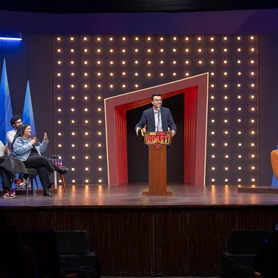 A wide shot of the 'Bro Code Roast' stage, capturing the host, the panel, and the audience. This gives a complete sense of the show's atmosphere and production value.