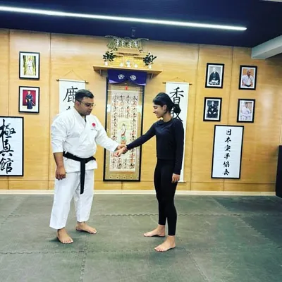 An instructor showing a technique to a female student. We are committed to empowering women through martial arts, fostering an environment of respect and strength.
