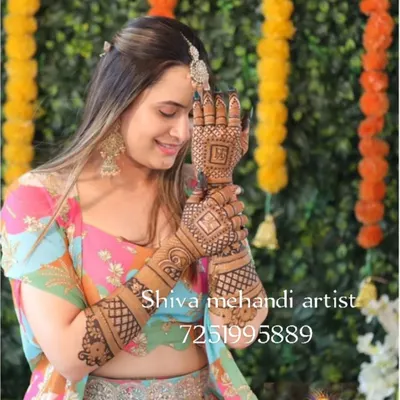 A happy client at a festive event, showing her elegant mehendi design. The artwork features clean lines and geometric patterns, a popular choice for party guests.