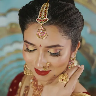 A close-up of this gorgeous bridal set. The rental includes the detailed maang tikka, a traditional nose ring (nath), and jhumkas that perfectly frame the face for those all-important wedding photos.