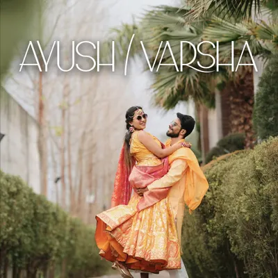 A joyful Haldi portrait, with the groom lifting the bride, both dressed in vibrant yellow outfits.