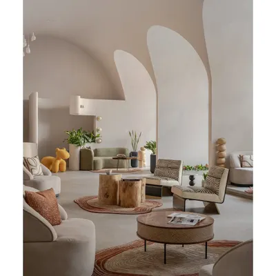A wide shot of the Vaultz's Up interior, showcasing how the intersecting vaults create a sculptural narrative. The space is unified by a neutral palette and punctuated by natural materials and greenery.