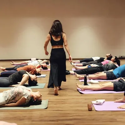 A class in Savasana, the final resting pose. This is a moment of collective surrender, where the benefits of the practice are absorbed in stillness.