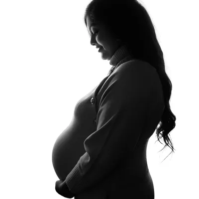 A simple, powerful silhouette. This high-contrast, black and white image beautifully highlights the profile of the mom-to-be, focusing on the incredible shape of pregnancy.