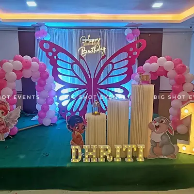 A full view of our butterfly-themed birthday decoration at Suswaad Restaurant, featuring a large prop, marquee lights, and character cutouts for a magical first birthday.