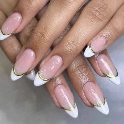A close-up of the modern French manicure with a delicate gold chrome line. This detail adds a touch of luxury and sophistication to the timeless style.