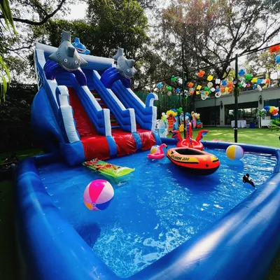 Making a splash! This pool party setup includes a large inflatable pool with a water slide, perfect for cooling off and having fun in the sun.