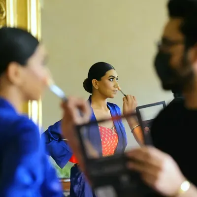 "Soon to be Mrs." A behind-the-scenes shot of the bride getting her makeup done, captured through a reflection. This shows the process and the team that helps create the final look.