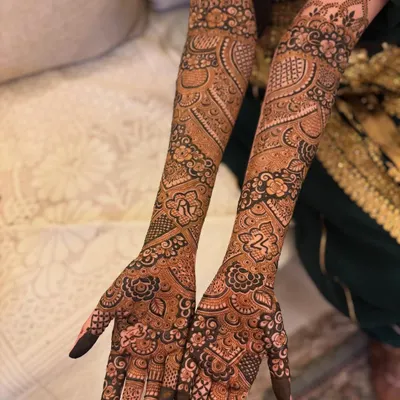 A full view of this personalized bridal mehendi, featuring the couple's initials 'R' and the number '24' beautifully integrated into the intricate Pakistani design.