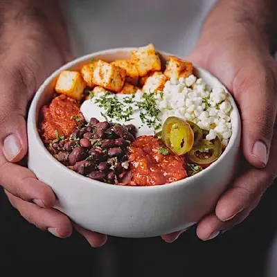 A bowl full of happiness, held in our hands. This is our promise of a fresh, flavorful, and satisfying meal, delivered right to you.