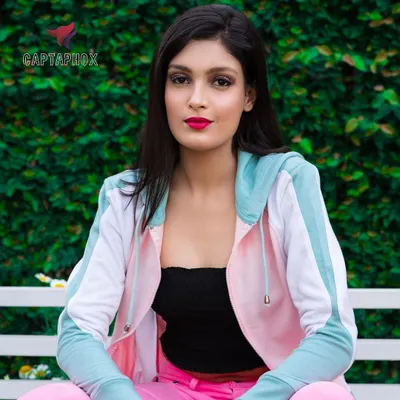 A relaxed, seated portrait taken outdoors against a lush green backdrop. This type of natural light photography is ideal for lifestyle brands, creating a relatable and approachable feel for casual wear catalogues.