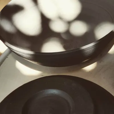 A stack of freshly thrown bowls catching the sunlight. There's such beauty in seeing a collection of work come together after a class.