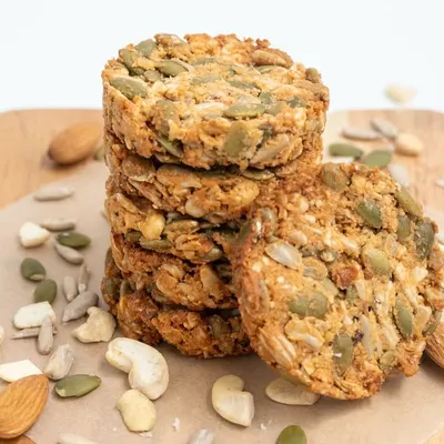 A stack of our healthy and wholesome multi-seed cookies. They are packed with nutritious ingredients like pumpkin seeds, sunflower seeds, almonds, and cashews.