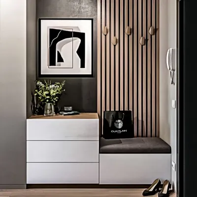 A chic and modern entryway unit featuring a cushioned bench seat, handleless white drawers, and a slatted wood panel with decorative hooks. This design combines style with practical storage.