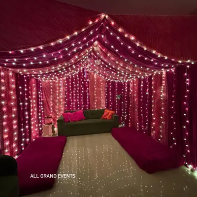 I transformed this living room into a beautiful tent-like space using vibrant pink bandhani and leheriya fabrics. The ceiling and walls are draped and lit with fairy lights for a magical, festive feel.